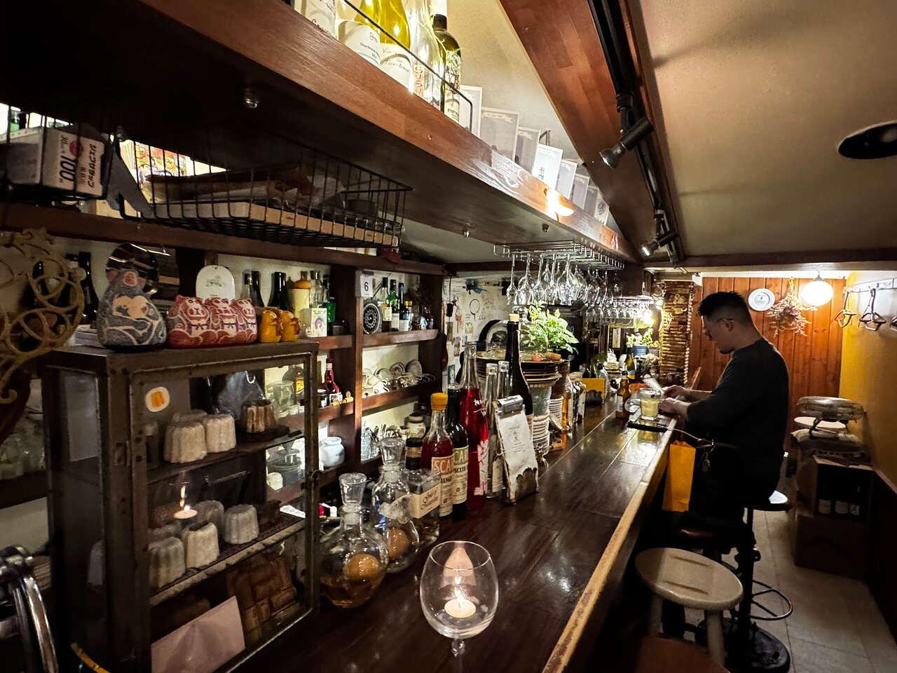 A long bar counter running beneath shelves of Japanese pottery
